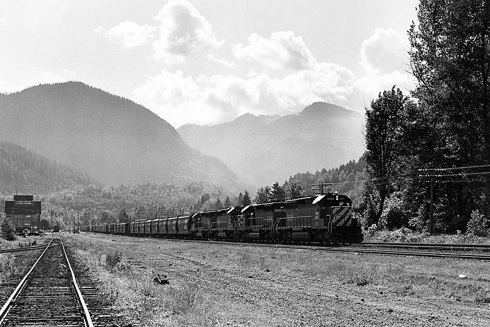 Black-and-white photo diesel locomotives with freight train in mountains